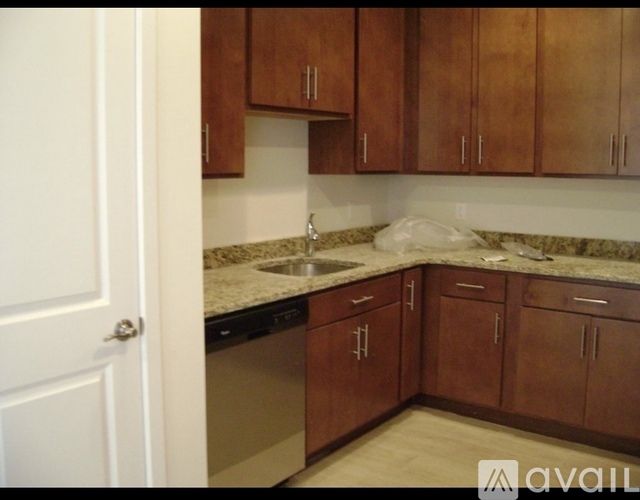 A kitchen with brown cabinets and a white door.
