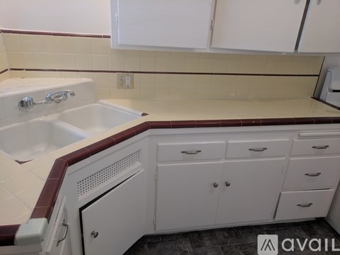 A white kitchen with a sink and cabinets.