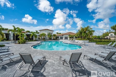 A pool surrounded by chairs and palm trees.