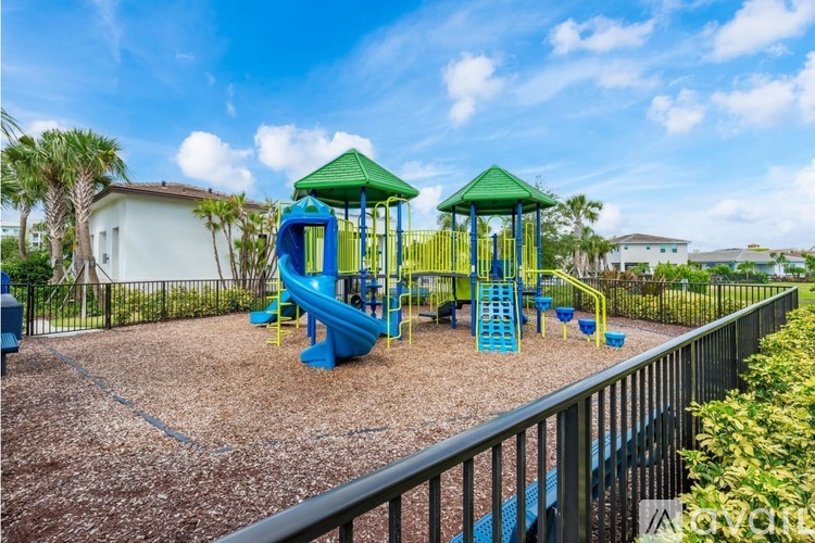 A playground with a blue slide and green roofed structures.