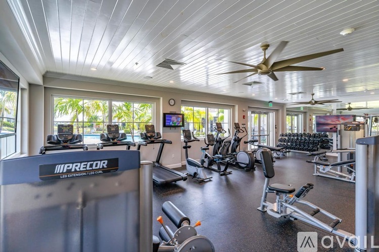 A gym with a variety of equipment including treadmills, stationary bikes, and weight machines.
