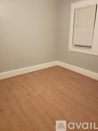A room with wooden flooring and a window.