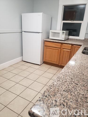 A kitchen with a granite countertop and white appliances.