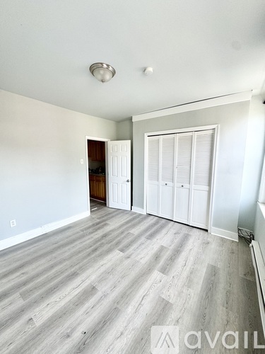 A room with a white door and a window with blinds.