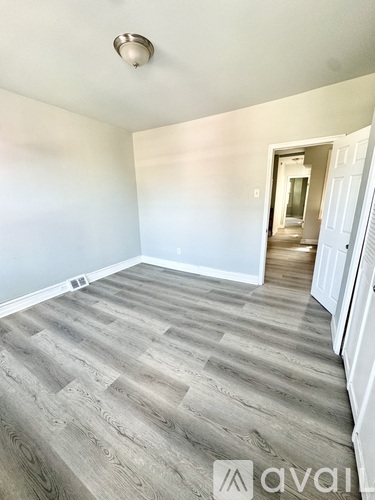 A room with wooden flooring and a white door.