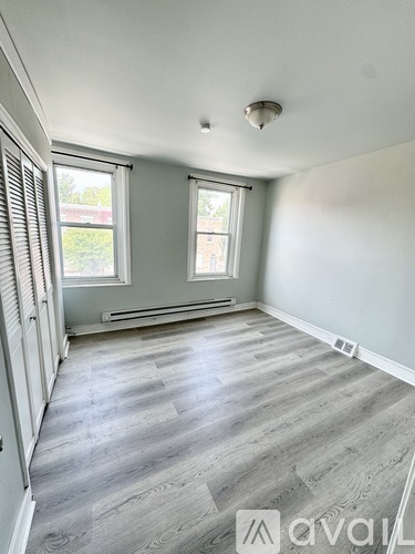 A room with a window and a wooden floor.