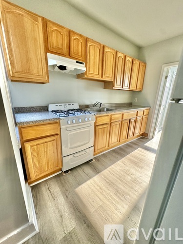 A kitchen with wooden cabinets and a white dishwasher.