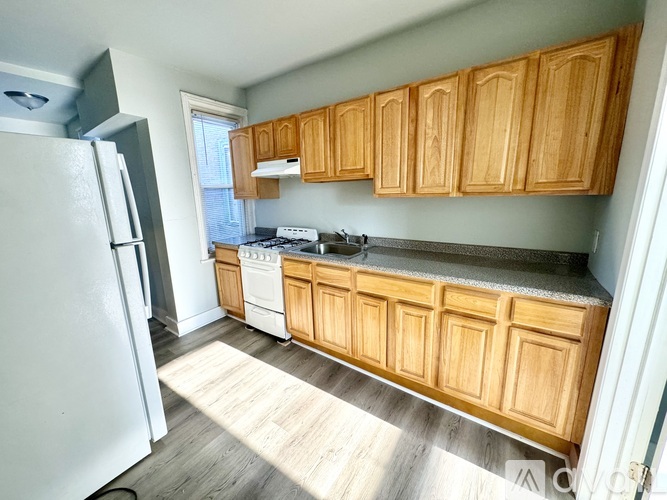 A kitchen with wooden cabinets and a white refrigerator.
