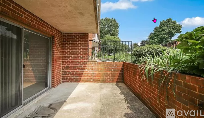 A balcony with a brick wall and a metal railing.