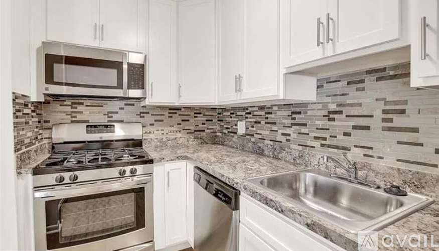 A kitchen with a stove, oven, microwave, and sink.