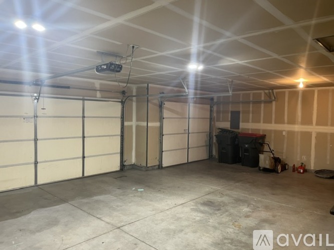 A spacious garage with a concrete floor and a ceiling with lights.