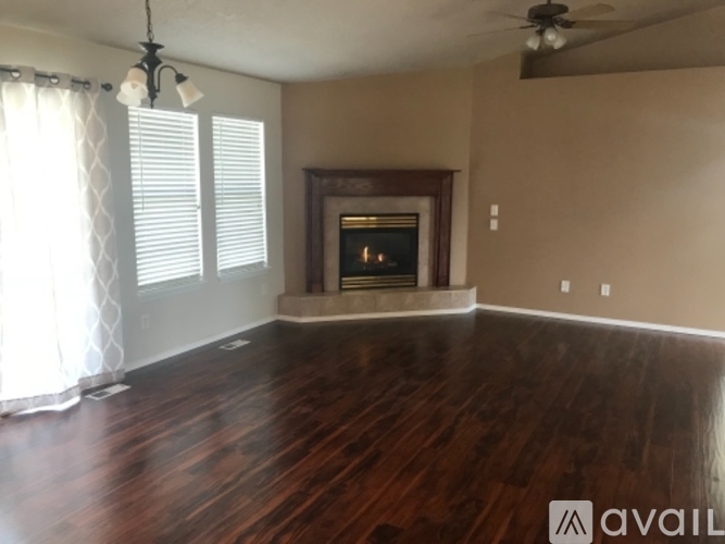 A living room with a fireplace and wood flooring.