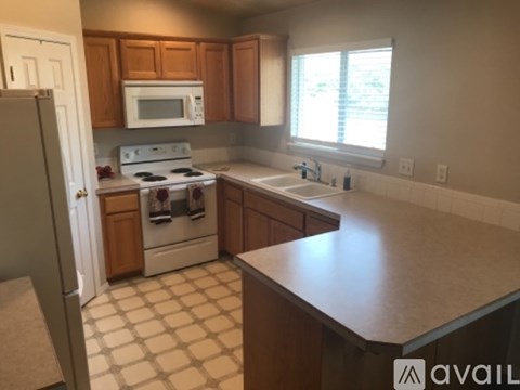 A kitchen with a white stove and wooden cabinets.