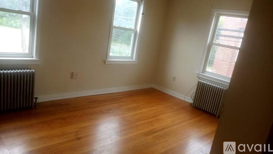 A room with wooden floors and two windows.