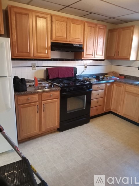 A kitchen with wooden cabinets and a black stove top oven.
