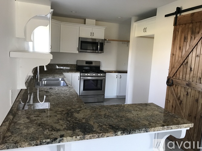 A kitchen with granite countertops and stainless steel appliances.