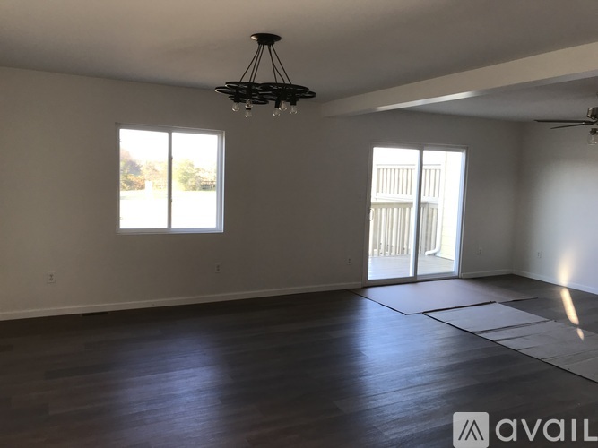 A spacious room with a ceiling fan and sliding glass doors.