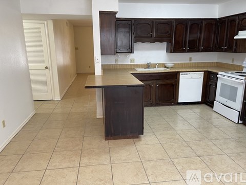 A kitchen with a black island in the middle.