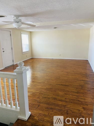 A room with wooden floors and a ceiling fan.