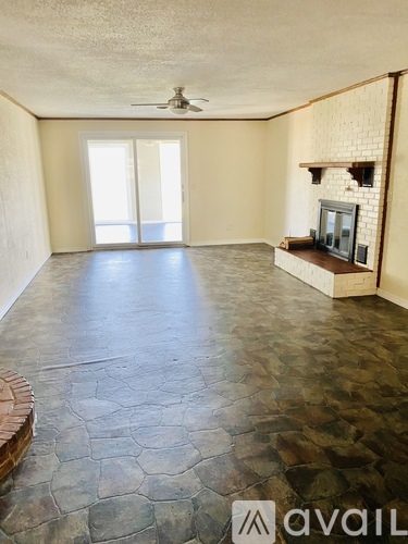A room with a stone floor and a fireplace.