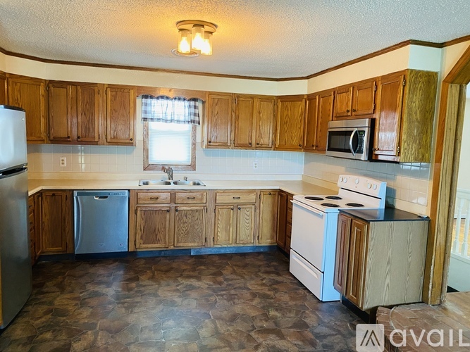 A kitchen with wooden cabinets and a stone floor.