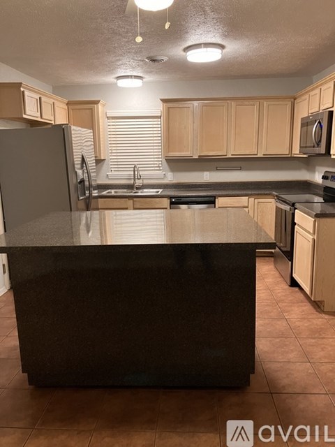 A kitchen with a black countertop and wooden cabinets.