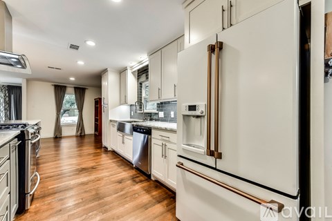 A modern kitchen with a large refrigerator and wooden floors.