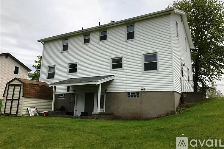 A white two story house with a brown roof.