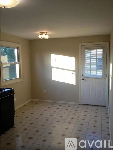 A room with a white door, a window with blinds, and a tiled floor.
