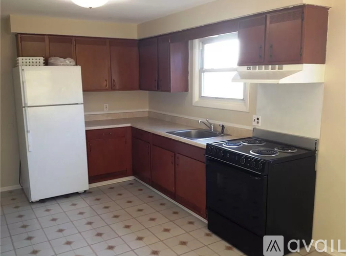 A kitchen with a black stove top oven and a white refrigerator.