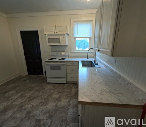 A kitchen with a black oven and white cabinets.