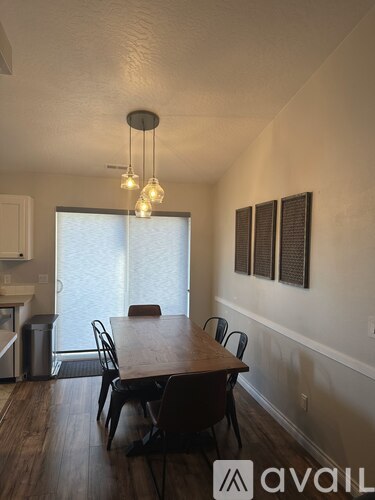 A dining room with a wooden table and chairs.