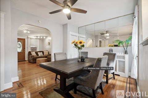 A dining room with a wooden table and chairs.