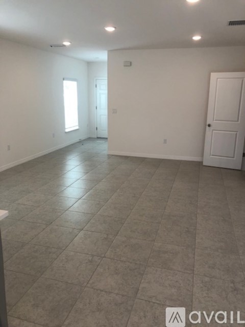 A spacious room with tile flooring and a single door.
