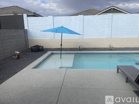 A blue umbrella is next to a pool.