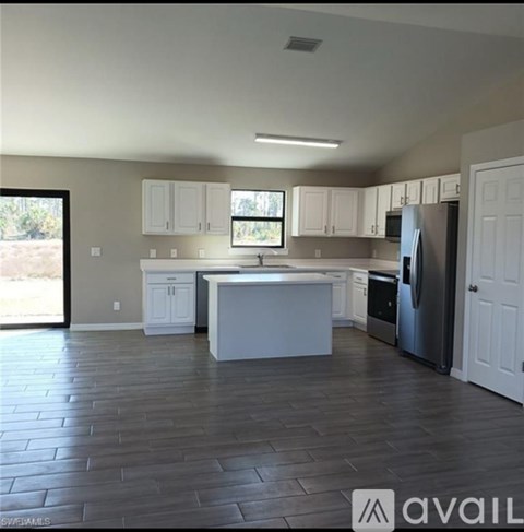 A kitchen with white cabinets and a wooden floor.