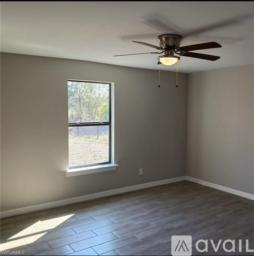 A room with a ceiling fan and a window.