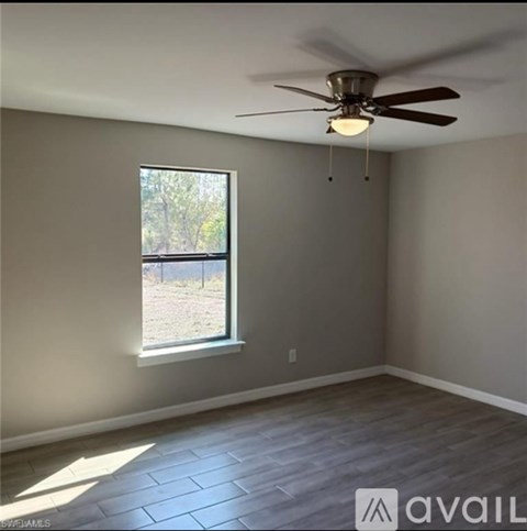 A room with a ceiling fan and a window.