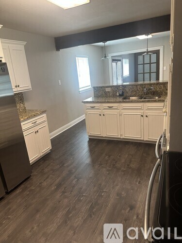 A kitchen with white cabinets and a granite countertop.