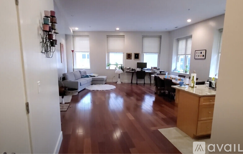 A living room with a kitchen area in the background.