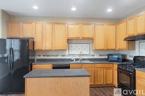 A kitchen with wooden cabinets and black appliances.
