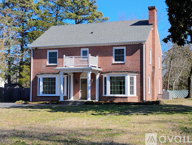 A red brick house with a white porch.