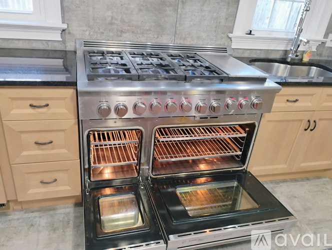 A modern kitchen with a stainless steel oven and wooden cabinets.