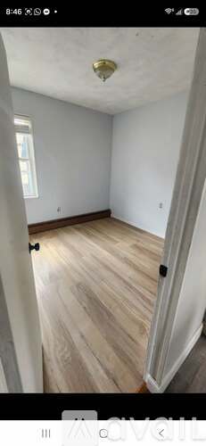 A room with wooden flooring and white walls.