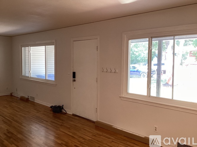 A room with a white door and a window with blinds.