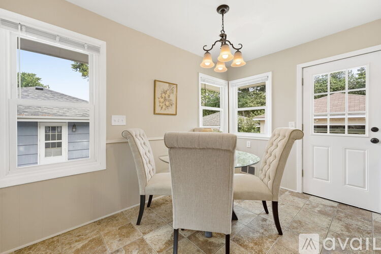 A dining room with a table and chairs.
