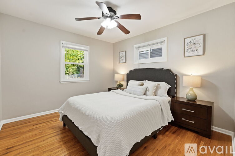 A bedroom with a bed, nightstand, and window.