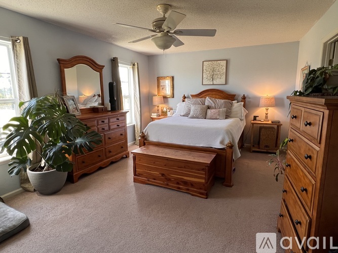 A bedroom with a bed, dresser, and mirror.