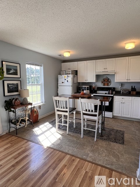 A kitchen with a table and chairs in the middle of the room.