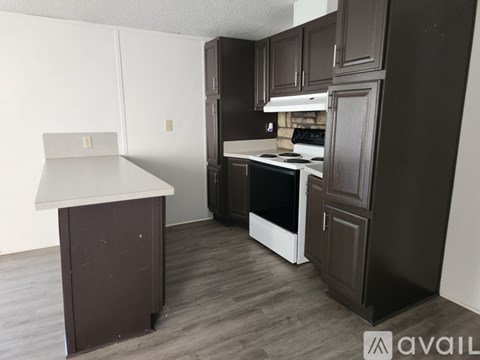 A kitchen with dark wood cabinets and a white countertop.